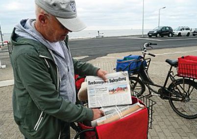 Die Austräger (Foto Johannes Visser) nehmen ihr Kontingent an Zeitungen am Hafen in Empfang, Die Auslieferung auf der Insel beginnt.