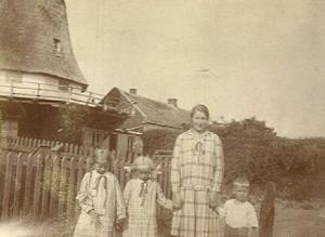 Das Hausmädchen der Familie Fleetjer mit Aafkea (ganz links), Elisabeth und einem eigenen Kind vor der Mühle